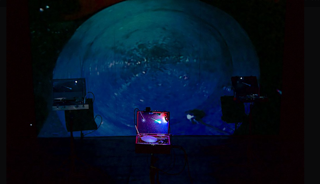 Imagen de la Instalación ¨En los tiempos del ruido¨ instrumentos y pantalla de fondo con la imagen en vivo