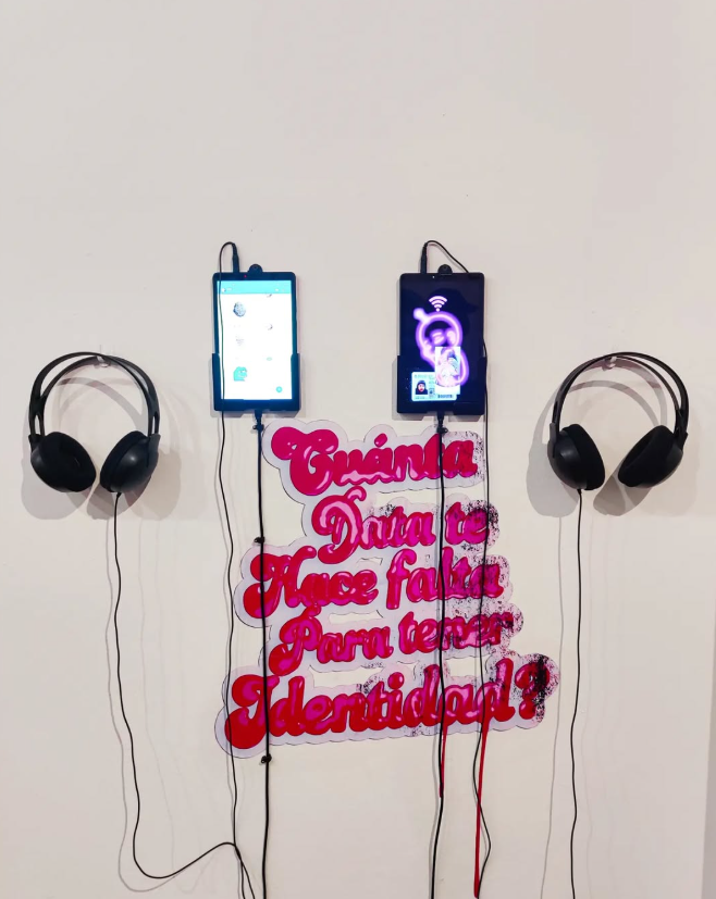 ¿Cuánta data te hace falta para tener identidad? Instalación con dos celulares, auriculares y la frase “¿Cuánta data te hace falta para tener identidad?” en la pared.
